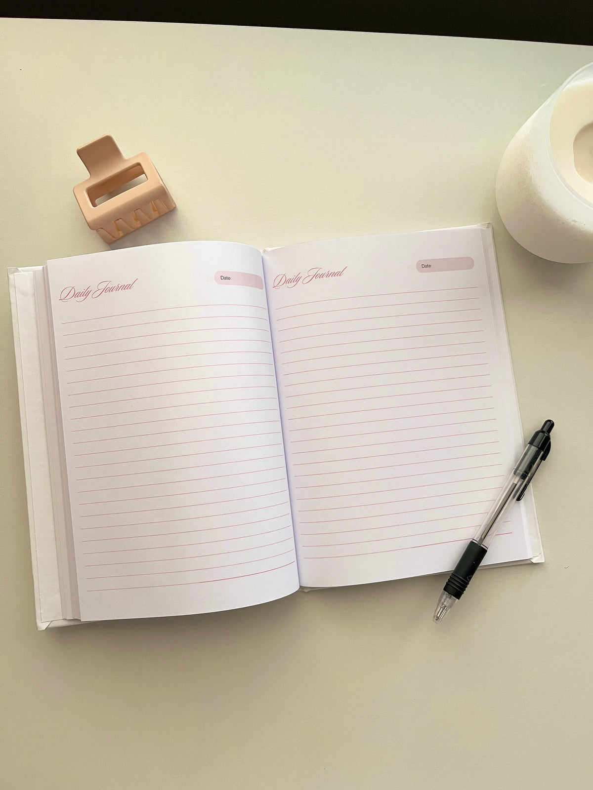 Open white daily journal showing lined pages and pink label headers