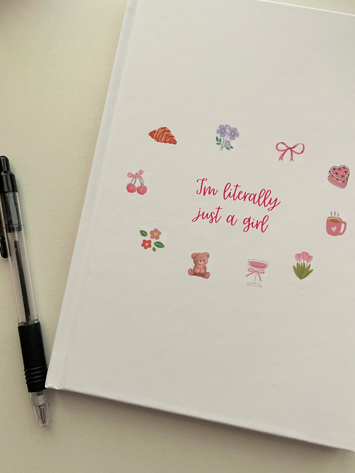 White journal cover with “I'm literally just a girl” slogan and small icons